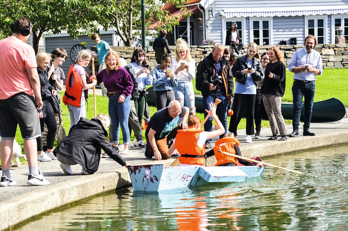 Ville farkostene flyte? Oppgaven var å lage en båt som kunne padles av to elever på vannet. Materiale er kun papp og gaffatape. Båtene ble forseglet ved at de brukte to lag med eksteriørmaling. Elevene fra Bergeland VGS, kunst, design og arkitektur, hadde et spennende oppstartprosjekt i faget design og bærekraft. Og farkostene ble testet under stor ståhei i Badedammen