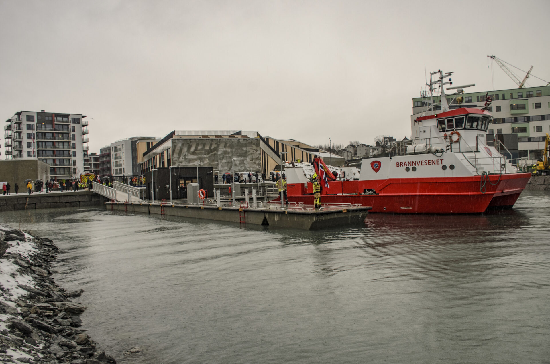 Brannstasjonen sett fra sjøsiden med brannbåten i forgrunnen.