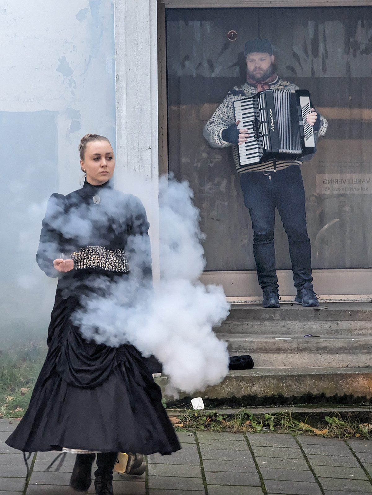 En røykfylt Sara Berge og en musiker med trekkspill møttes i Pedersgata. Foto Sigrid Bækholt